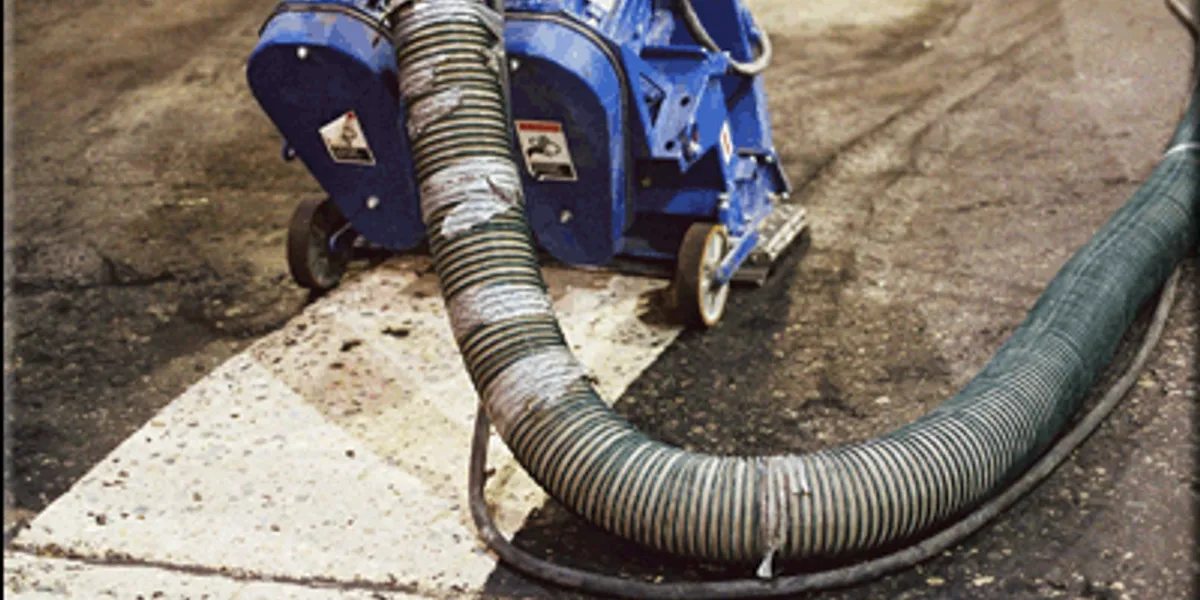 A blue machine is on the ground with its hose attached.