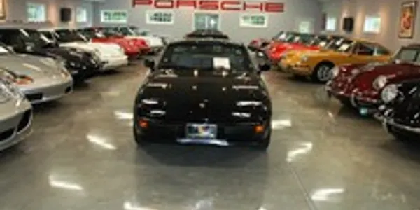 A black car is parked in the middle of a showroom.