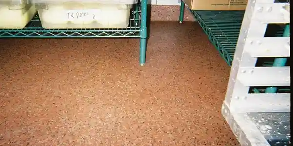 A floor with some green shelves and brown flooring