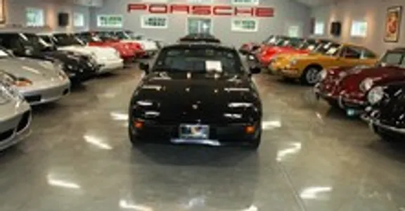 A black car is parked in the middle of a showroom.