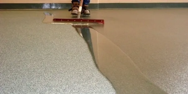 A person is using a floor squeegee to clean the floor.